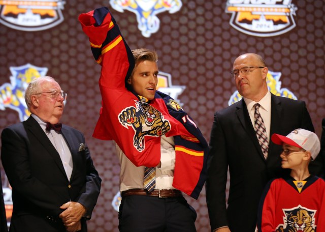Aaron Ekblad puts on a team jersey after being selected as the number one overall pick to the Florida Panthers. (Bill Streicher, USA TODAY Sports)