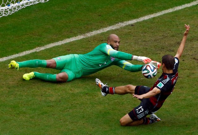 Germany's Thomas Mueller challenges goalkeeper Tim Howard of the U.S. (REUTERS/Ruben Sprich)