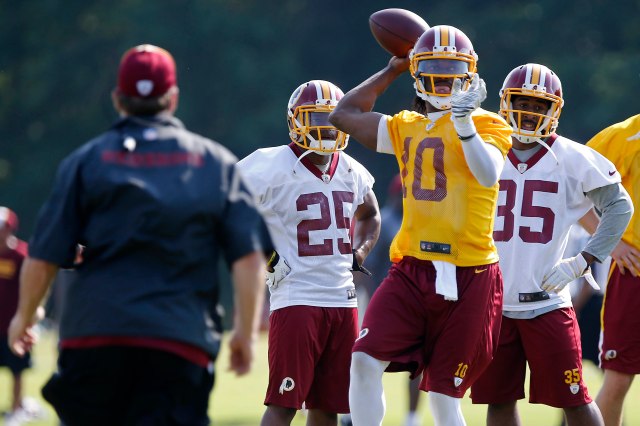 Redskins QB Robert Griffin III (10) remain more composed than some of his teammates in the Ashburn, Va., heat Tuesday. (Geoff Burke, USA TODAY Sports)