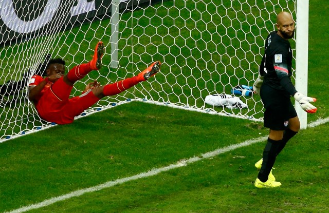 Belgium's Divock Origi throws himself into the goal net, behind goalkeeper Tim Howard of the U.S, after missing an opportunity to score a goal. (REUTERS/Ruben Sprich)