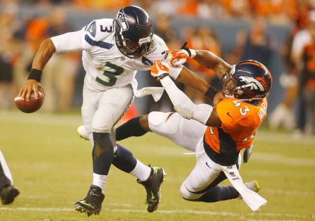 Seahawks QB Russell Wilson gets harassed by Broncos S T.J. Ward on Thursday night. (Chris Humphreys-USA TODAY Sports)