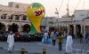 People walk past a FIFA World Cup trophy decorating the Souq Waqif in the Qatari capital Doha. Photo via Karim Jaafar/AFP