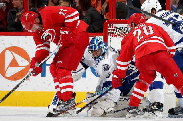 RALEIGH, NC - DECEMBER 04: Lee Stempniak #21 and Sebastian Aho #20 of the Carolina Hurricanes look to jam a loose puck past Ben Bishop #30 of the Tampa Bay Lightning during an NHL game on December 4, 2016 at PNC Arena in Raleigh, North Carolina. (Photo by Gregg Forwerck/NHLI via Getty Images)