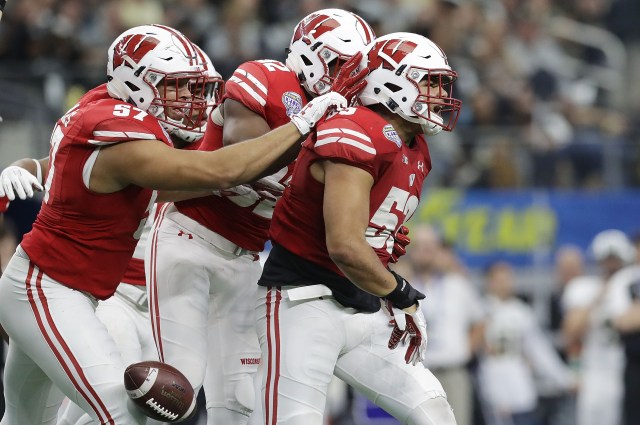 ARLINGTON, TX - JANUARY 02: T.J. Edwards #53, Alec James #57, and Leon Jacobs #32 of the Wisconsin Badgers celebrate after an interception in the fourth quarter during the 81st Goodyear Cotton Bowl Classic between Western Michigan and Wisconsin at AT&T Stadium on January 2, 2017 in Arlington, Texas. (Photo by Ronald Martinez/Getty Images)