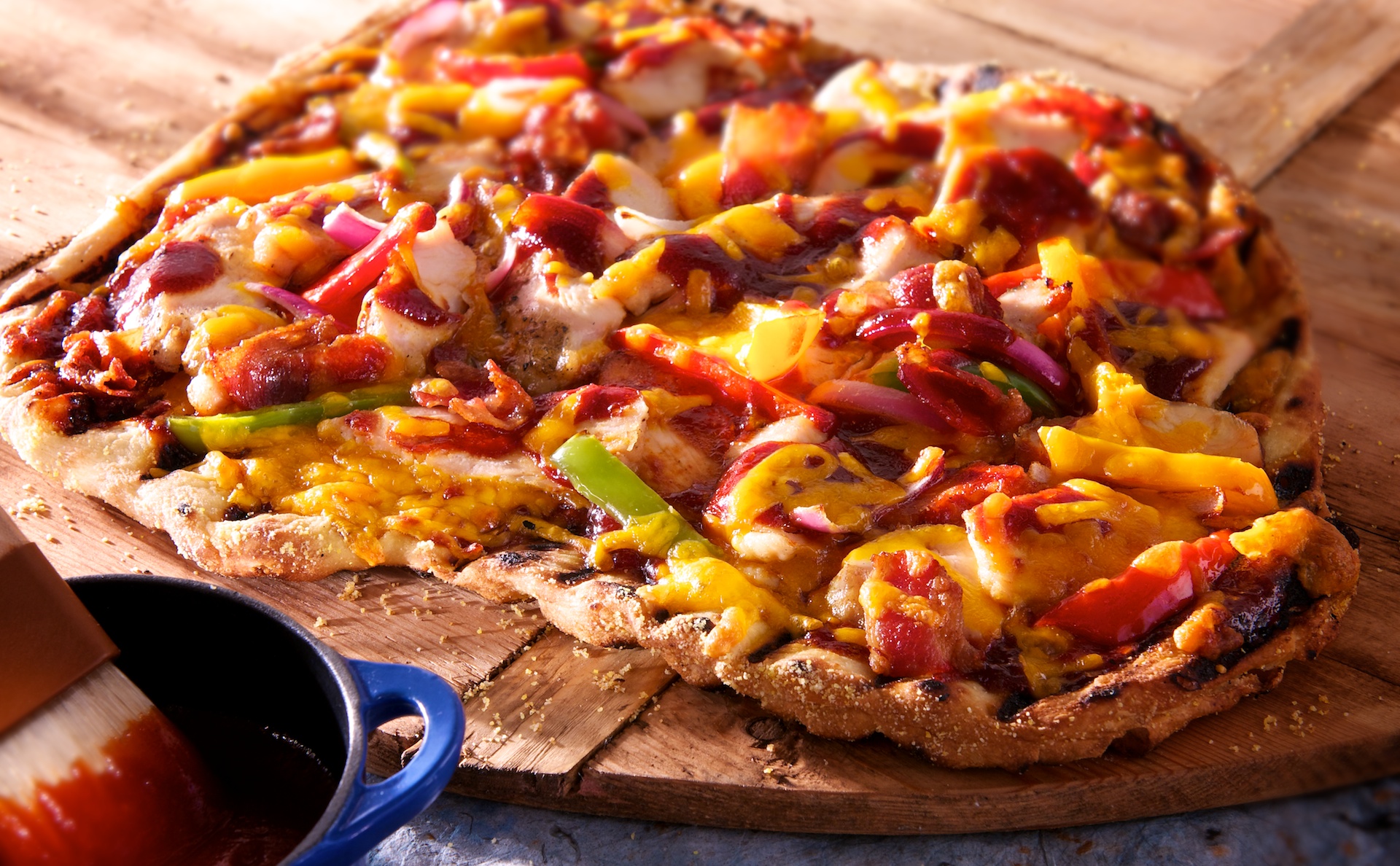 For this classic BBQ grilled pizza, we layered smoky char grilled chicken, bell peppers, red onions, sizzling bacon, barbecue sauce and sharp Cheddar cheese on thin crust pizza dough grilled until golden and bubbly.