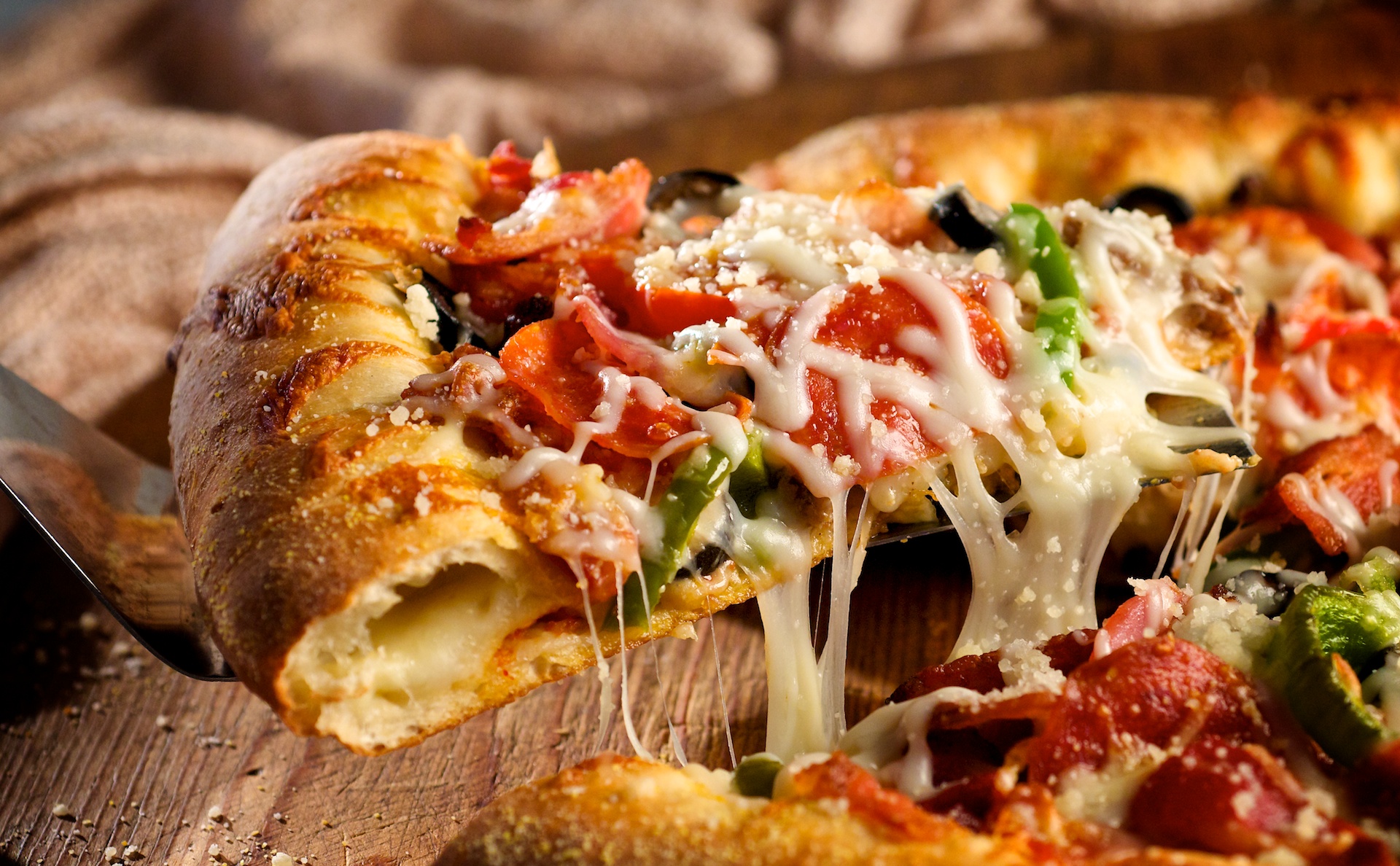 This is a hearty stuffed-crust pizza layered with four types of meat, black olives, and peppers all smothered in a gooey melted Mozzarella cheese. Need we say more?