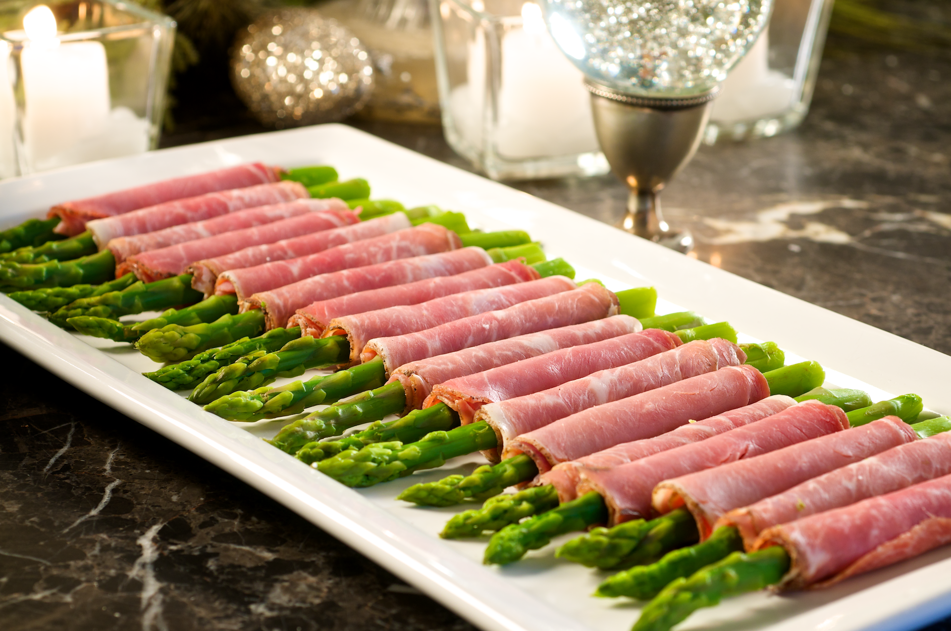 This simple and fresh appetizer adds color and nurtrition to your buffet table! The salty, slightly chewy, prosciutto is perfect to complement the al dente asparagus.