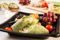 Our healthy Mediterranean-inspired bento box includes a grilled chicken and feta wrap, hummus dip, kalamata olives, crunchy pita chips and fresh grapes.