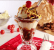 Photographic depiction of an ice cream sundae, based on one served during NASCAR races at the Kansas International Speedway. Visual shows an ice cream sundae glass layered with mashed potatoes instead of ice cream, brisket and barbecue sauce.