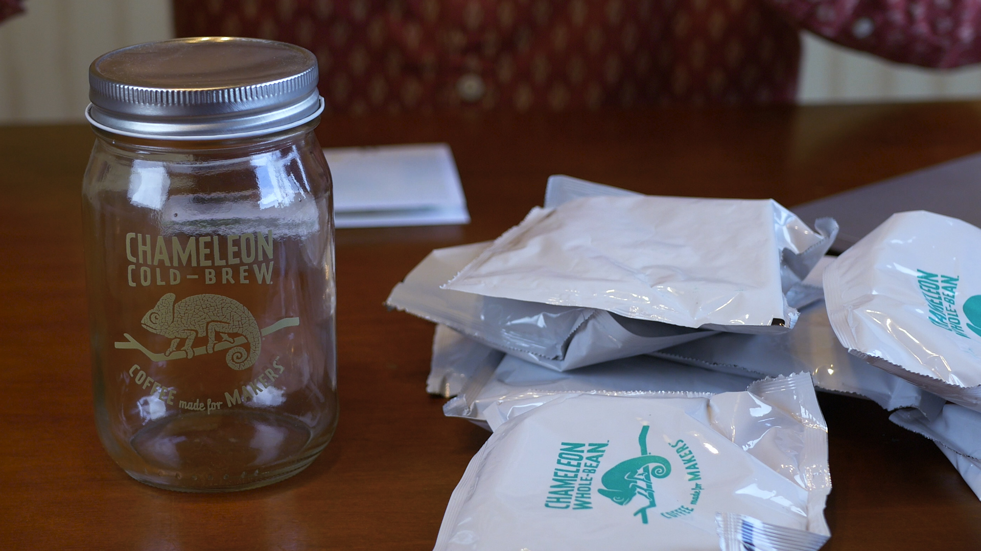 Photo of Chameleon Whole Bean coffee packet and a mason jar for brewing