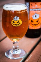 Photo depiction of a glass of pumpkin beer poured into a serving glass. 