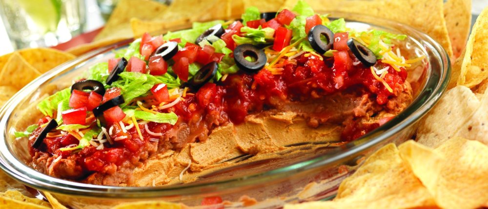 Great for game day and casual gatherings, this kicked-up Southwestern-style seven-layer dip recipe will score big with your guests. A glass pie plate is perfect for this dip, but you can also use a disposable football-shaped dish to enhance the football theme!