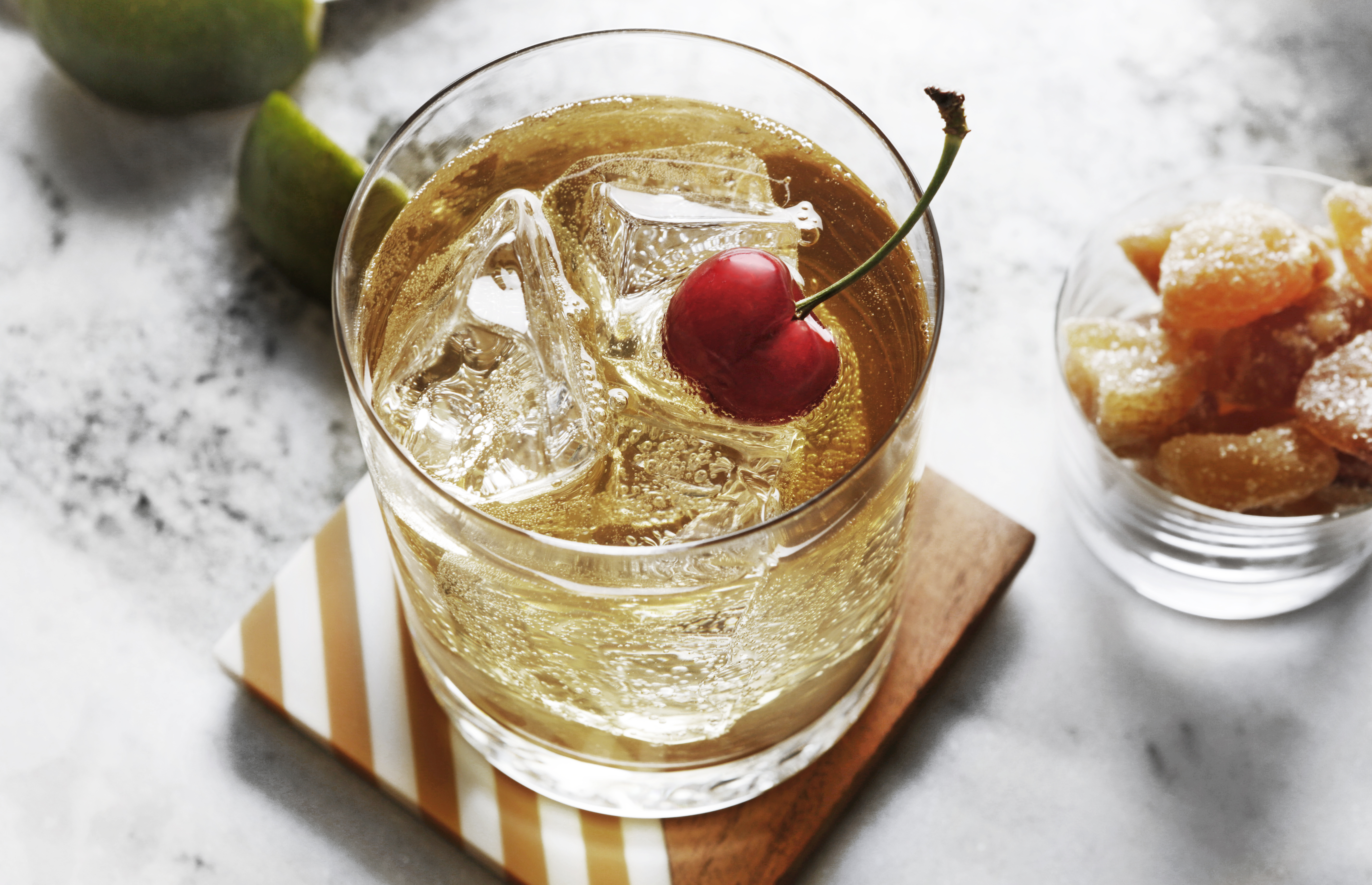 Pour vodka and ginger ale into a rocks glass filled with ice and stir briefly. Squeeze fresh lime juice on top. Garnish with a cherry.