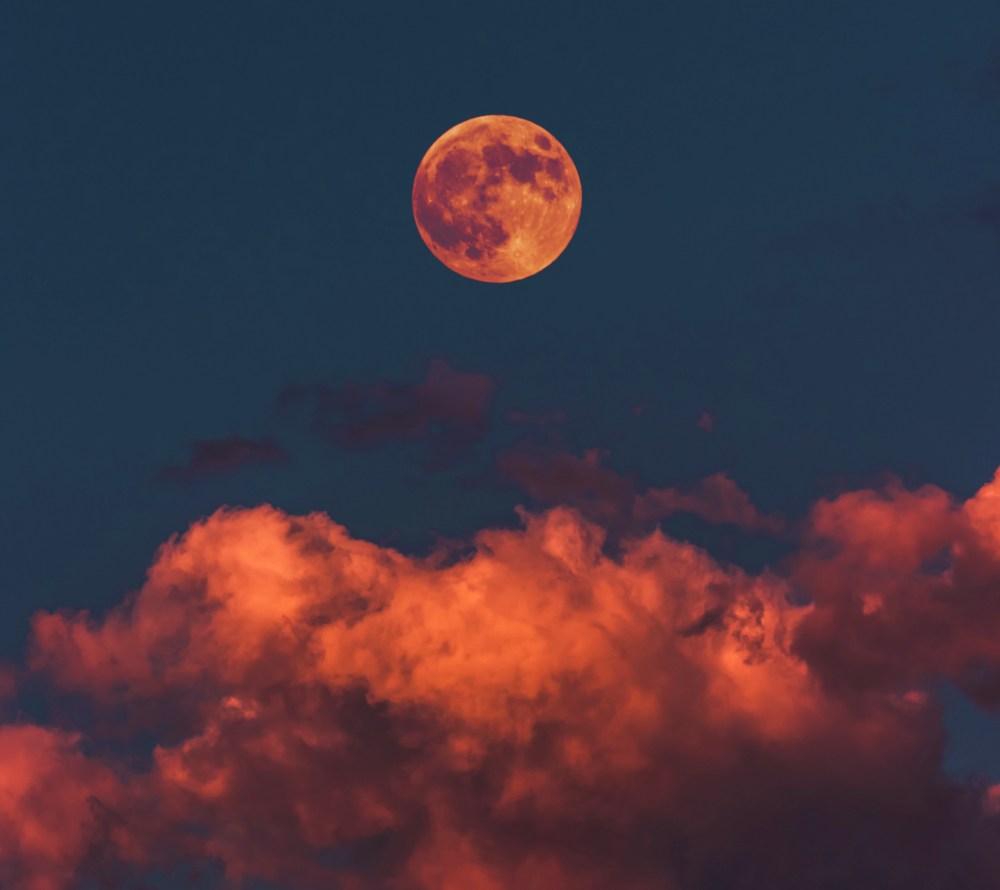 A full moon rises over a cloudy sky, the perfect setting for a Halloween celebration. 