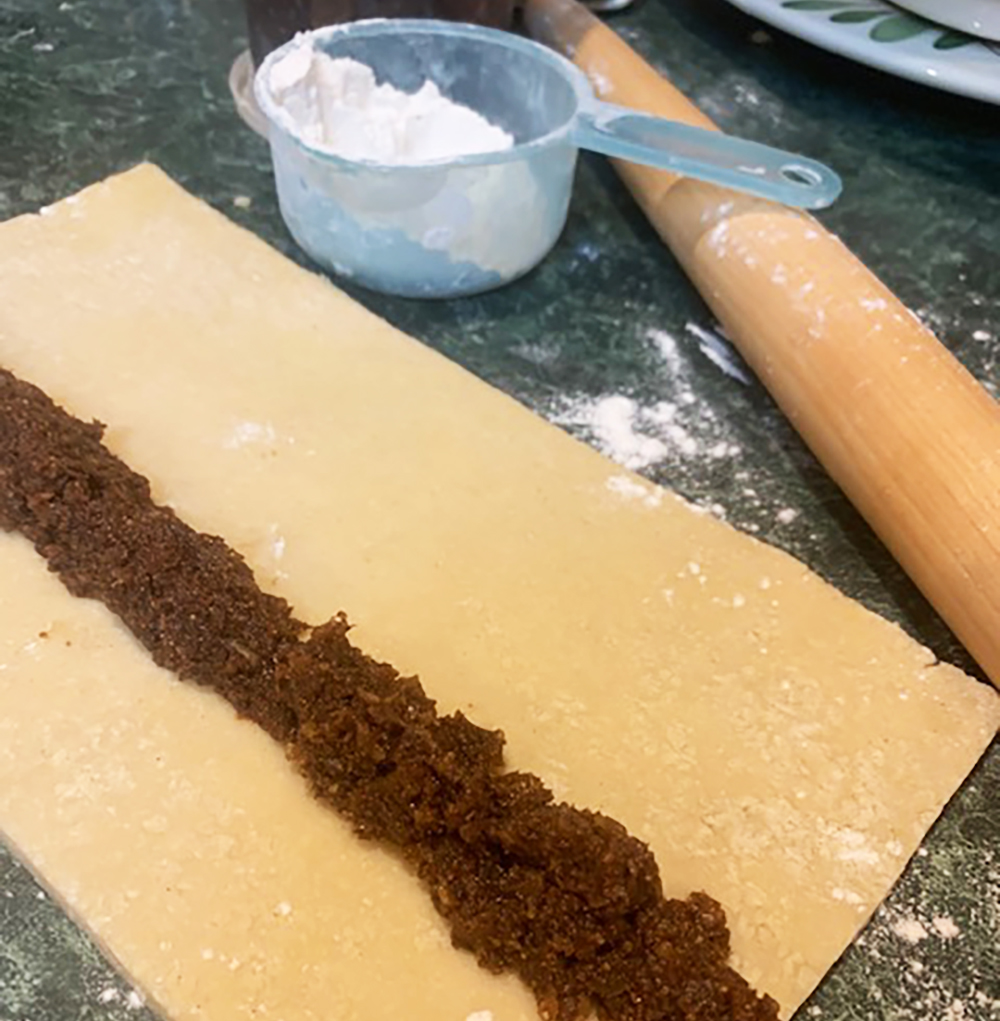 Placing the filling in the center of the rolled dough.