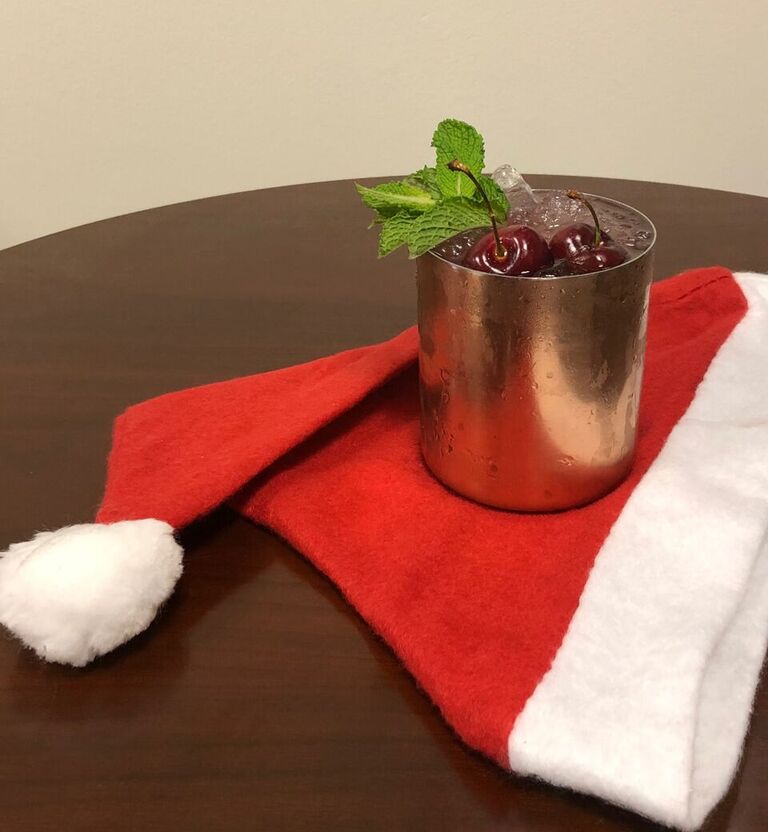 Combine lime, ginger, pomegranate, and cherries. Muddle down to a paste. Add vodka and shake. Double strain into a copper mug with 2 oz. ginger beer in the bottom. Garnish with fresh cherries and mint sprig. Used shaved ice on top for effect.