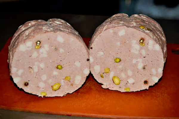 A whole mortadella sausage, cut in half to demonstrate how it should look, after being ground by hand, backed and chilled in the refrigerator for two days. 
