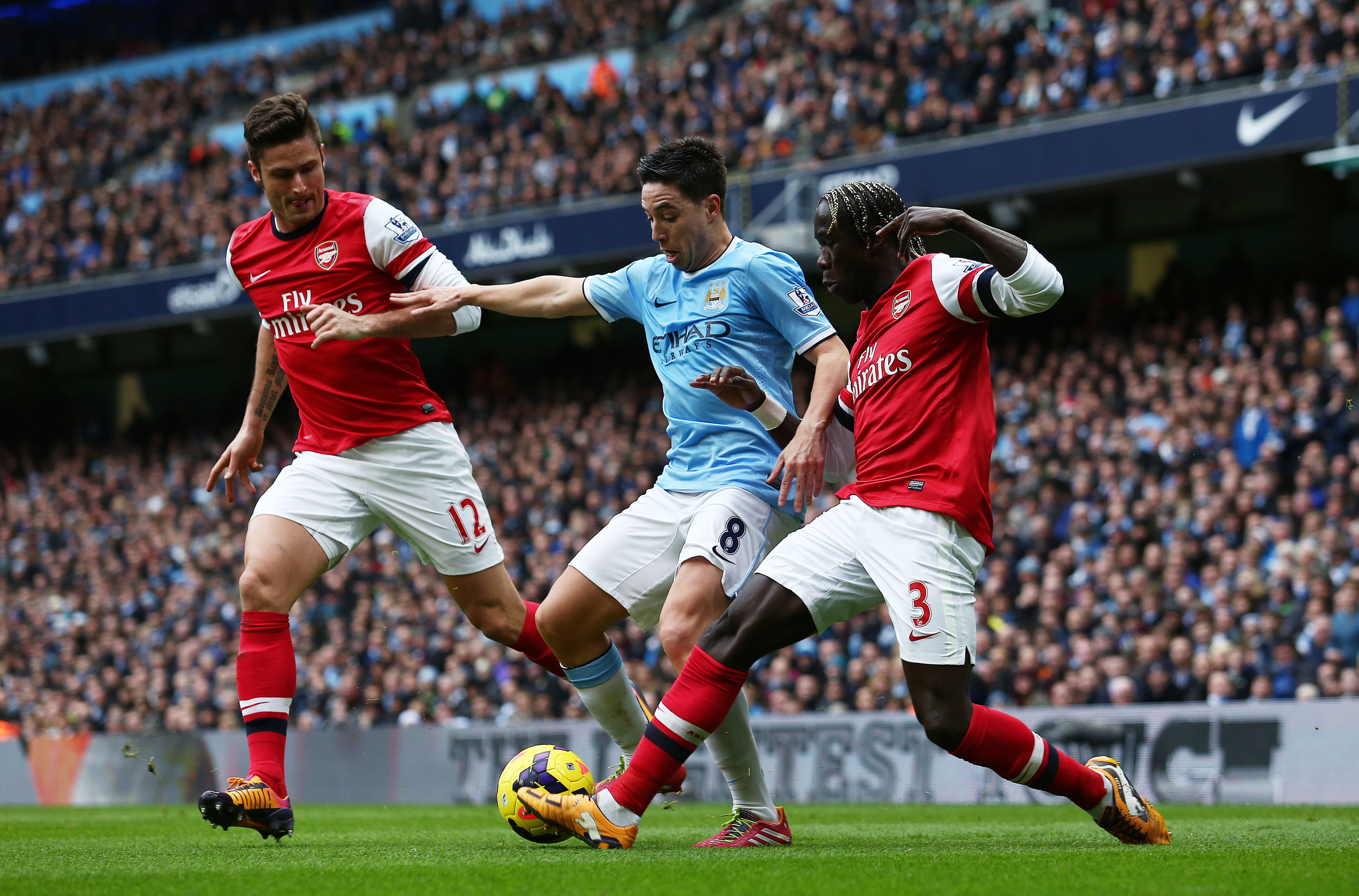 Samir Nasri of Manchester City in between Olivier Giroud and Bacary Sagna of Arsenal