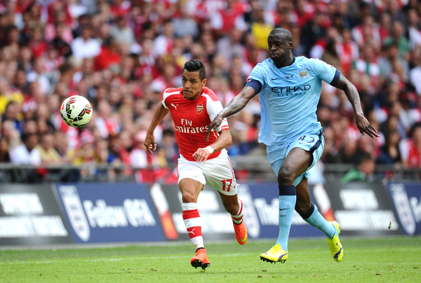 Alexis Sanchez of Arsenal and Yaya Toure of Manchester City chase the ball