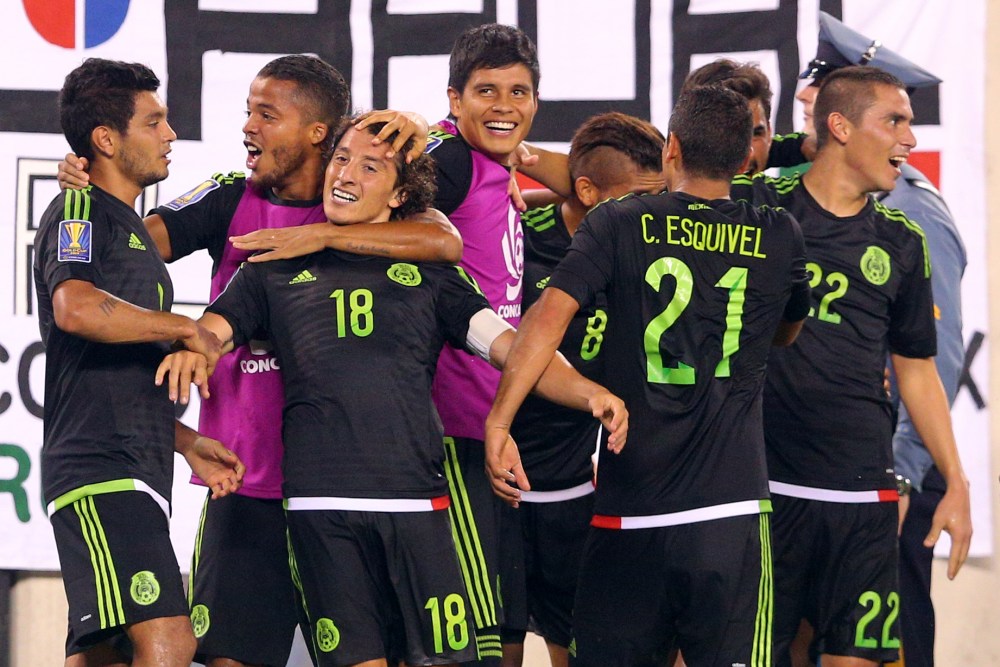 Jul 19, 2015; East Rutherford, NJ, USA; Mexico midfielder Andres Guardado (18) celebrates with teammates after kicking a penalty kick to score a goal against Costa Rica during stoppage time of the overtime period of a CONCACAF Gold Cup quarterfinal match at MetLife Stadium. Mexico won 1-0 in overtime. Mandatory Credit: Brad Penner-USA TODAY Sports