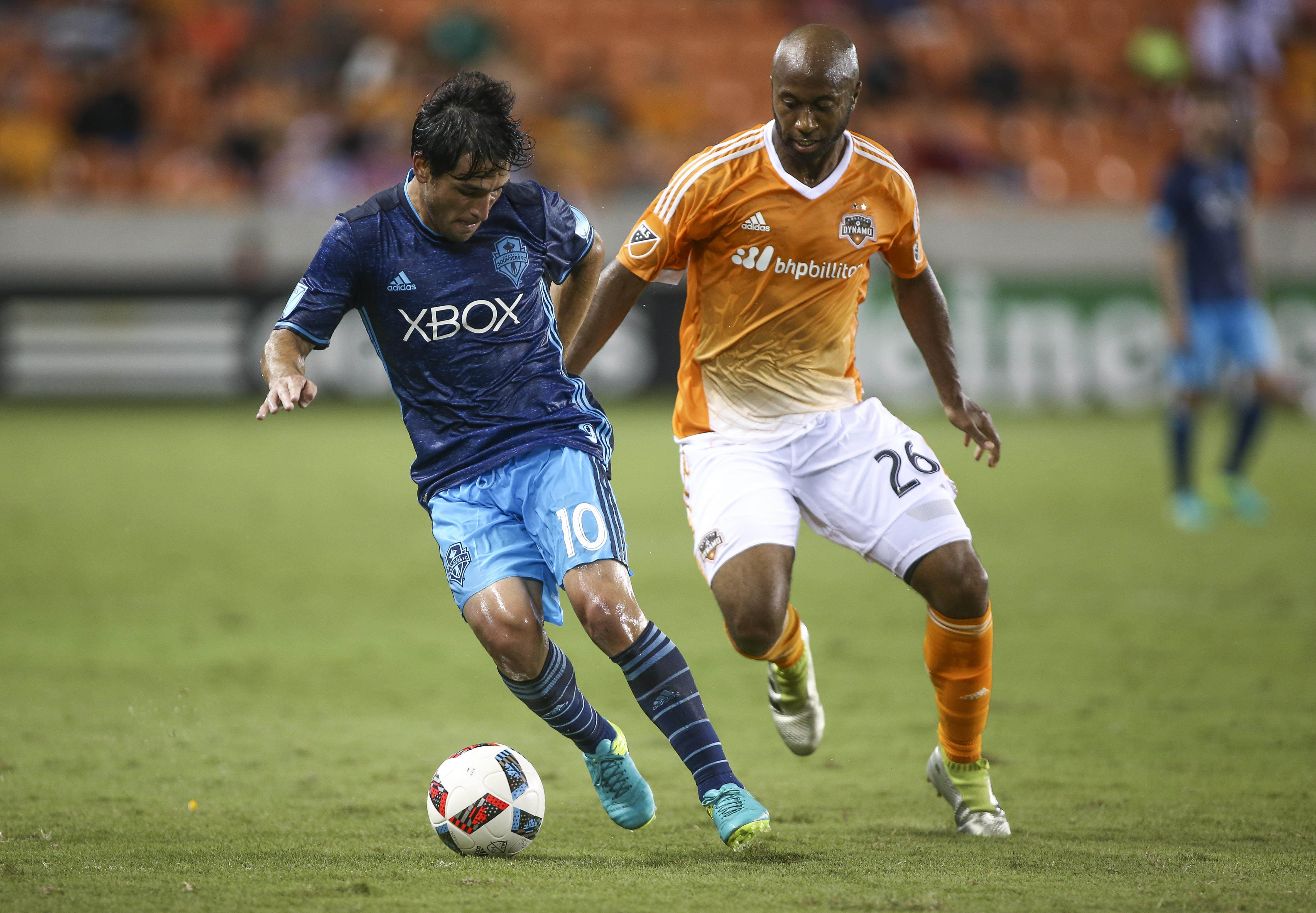 Aug 24, 2016; Houston, TX, USA; Seattle Sounders midfielder Nicolas Lodeiro (10) and Houston Dynamo midfielder Collen Warner (26) battle for the ball during the first half at BBVA Compass Stadium. Mandatory Credit: Troy Taormina-USA TODAY Sports