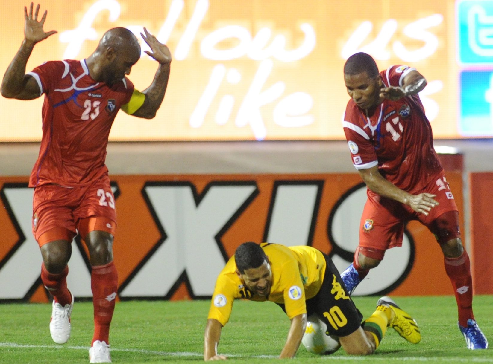 Panamanian players (L) Felipe Baloy and Luis Henriquez (R) try to avoid the fallen Joel McAnuf (C) of Jamaica during their Concacaf World Cup qualifier Jamaica vs Panma at the National Stadium in Kingston, Jamaica. AFP PHOTO / Ricardo MAKYN (Photo credit should read RICARDO MAKYN/AFP/Getty Images)