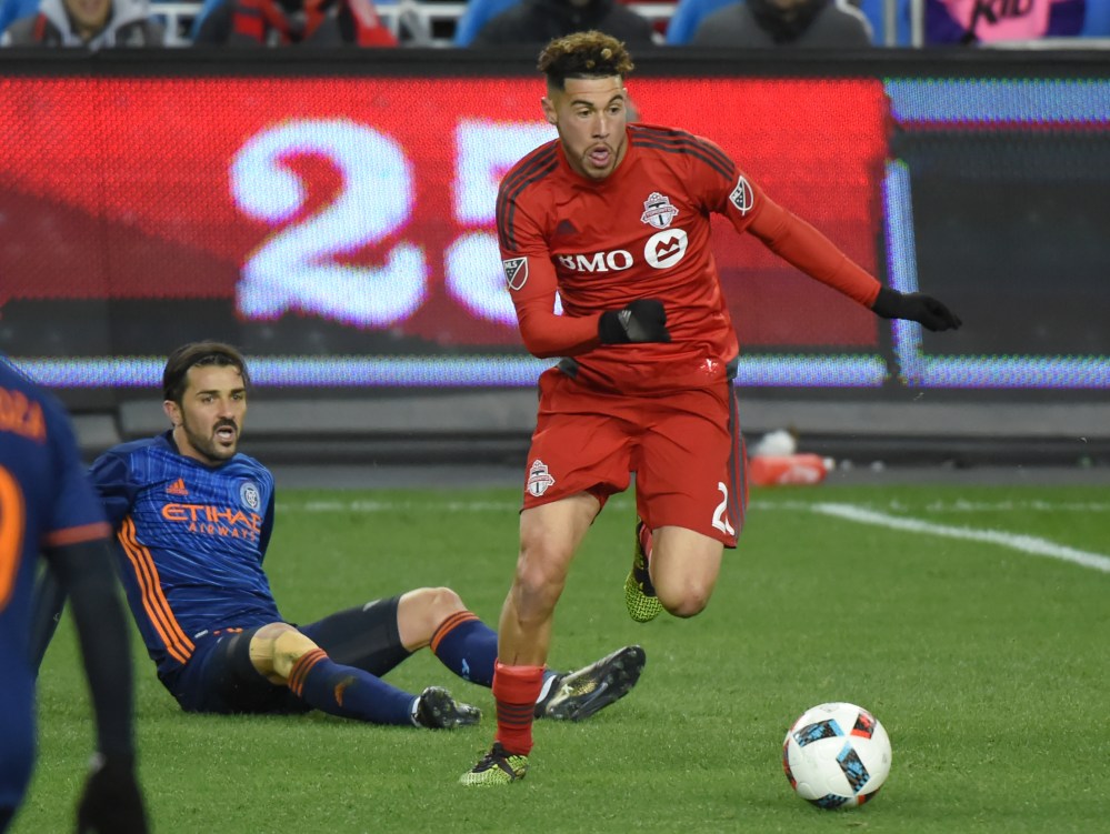 Oct 30, 2016; Toronto, Ontario, CAN; Toronto FC midfielder Jonathan Osorio (21) dribbles the ball away from New York City FC forward David Villa (7) during the second half at BMO Field. Mandatory Credit: Dan Hamilton-USA TODAY Sports