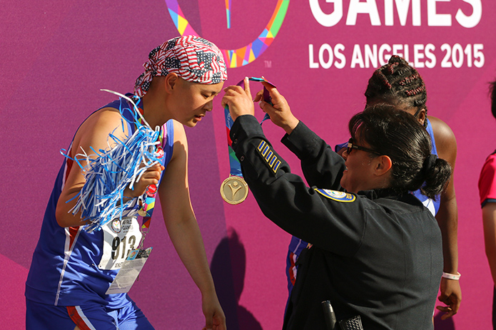Olivia gets the gold medal placed over her head. (Aaron Mills/Special Olympics USA) 