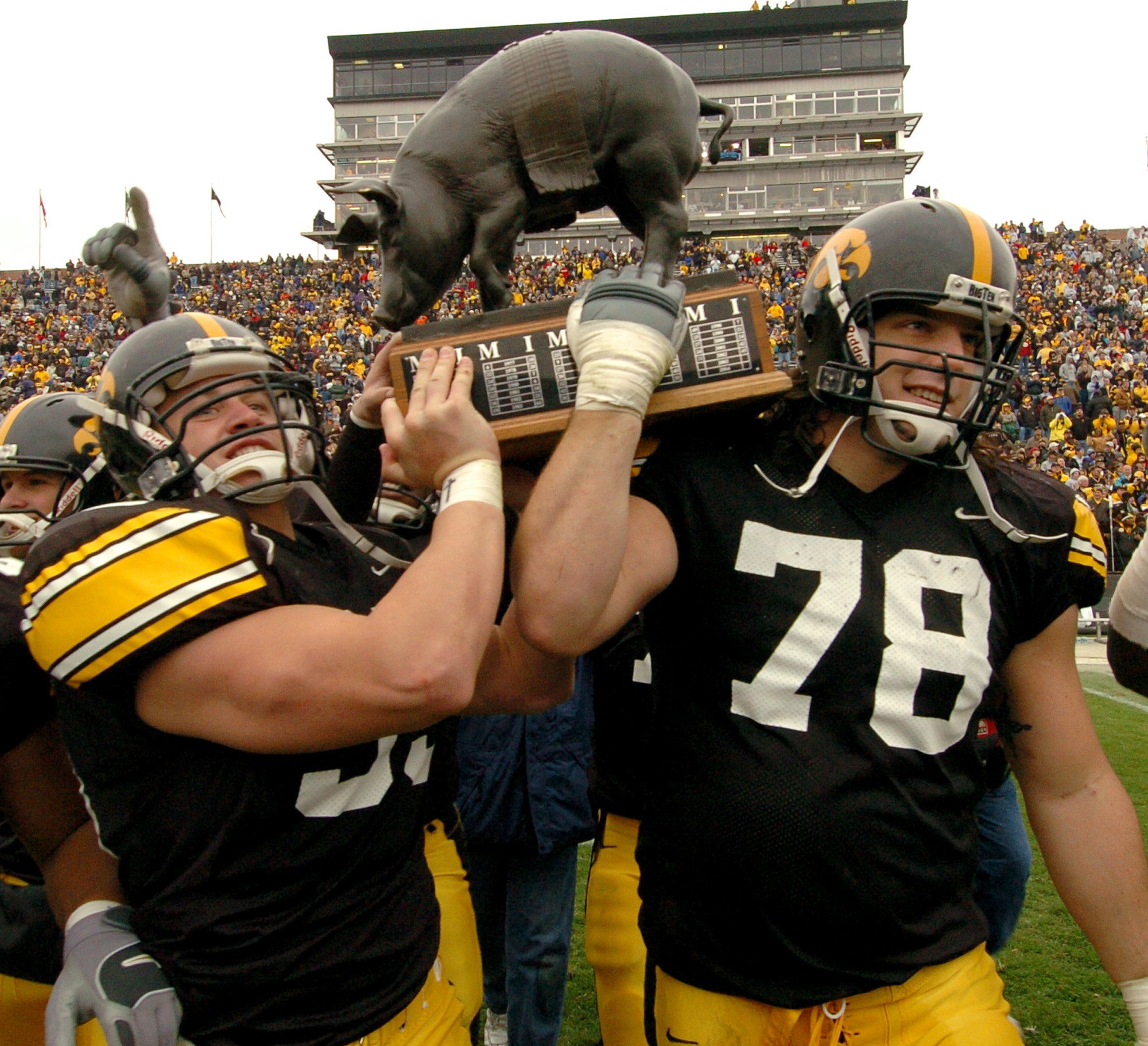 Iowa's Erik Jensen, left, and Iowa's Robert Gallery, right, hoist the bronze pig-shaped trophy known as Floyd of Rosedale in celebration of their 40-22 win over Minnesota, Saturday, Nov. 15, 2003, in Iowa City, Iowa. (AP Photo/Chris Donahue) ORG XMIT: IACD103