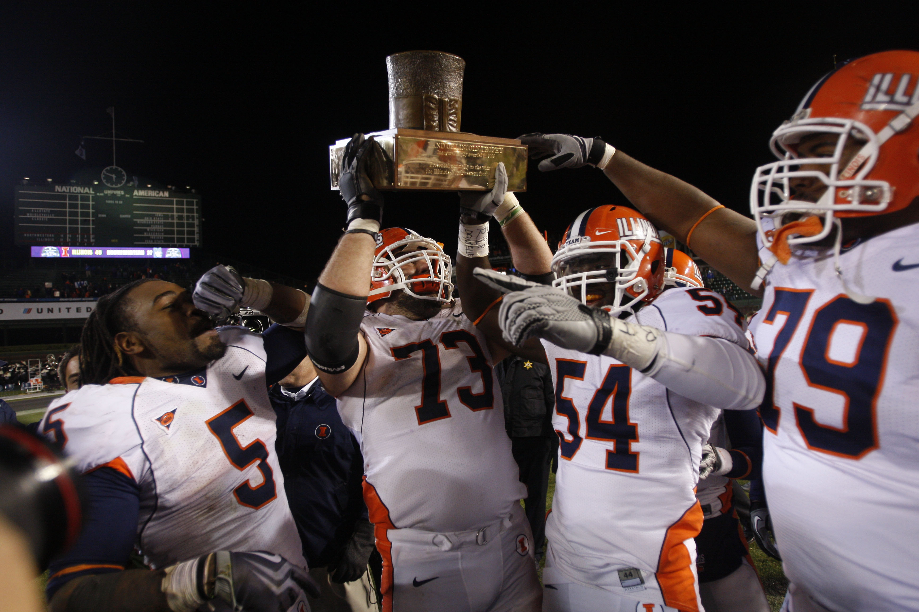 Nov 20, 2010; Chicago, IL, USA; Illinois Fighting Illini players including Jack Cornell (73) and Mikel Leshoure (5) and Justin Staples (54) and Craig Wilson (79) celebrate with the Land of Lincoln trophy after defeating the Northwestern Wildcats 48-27 at Wrigley Field. Mandatory Credit: Jerry Lai-US PRESSWIRE ORIG FILE ID: 20101120_jel_sl8_039.jpg