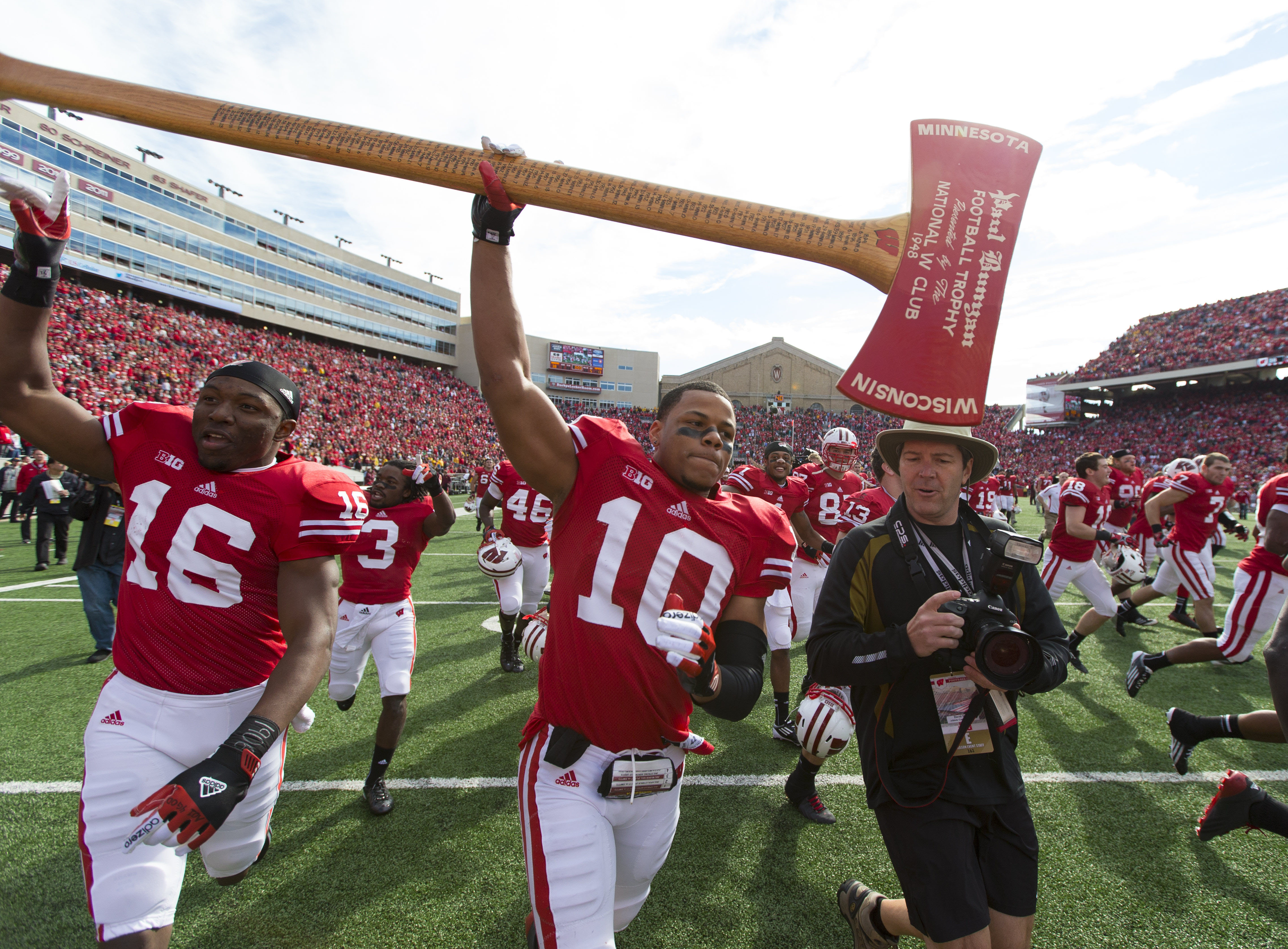 Oct 20, 2012; Madison, WI, USA; Wisconsin Badgers defensive back Devin Smith (10) (center) and wide receiver Reggie Love (16) (left) celebrate with the Paul Bunyan Axe following the game against the Minnesota Golden Gophers at Camp Randall Stadium. Wisconsin defeated Minnesota 38-13. Mandatory Credit: Jeff Hanisch-US PRESSWIRE ORG XMIT: USPW-91318 ORIG FILE ID: 20121020_gav_sh5_081.JPG