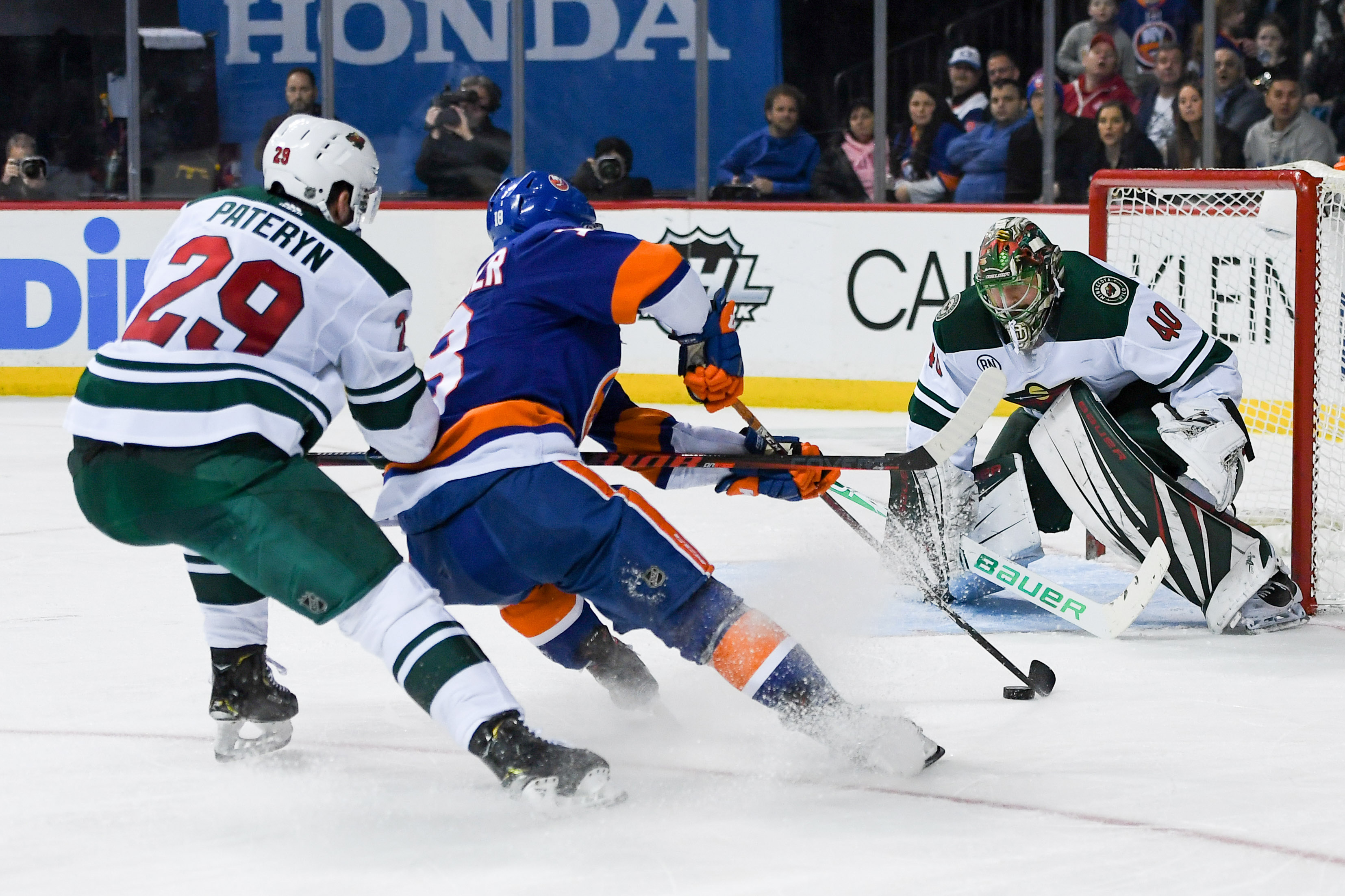 Feb 10, 2019; Brooklyn, NY, USA; New York Islanders left wing Anthony Beauvillier (18) skates with the puck around Minnesota Wild defenseman Greg Pateryn (29) as Wild goaltender Devan Dubnyk (40) defends during the second period at Barclays Center. Mandatory Credit: Dennis Schneidler-USA TODAY Sports