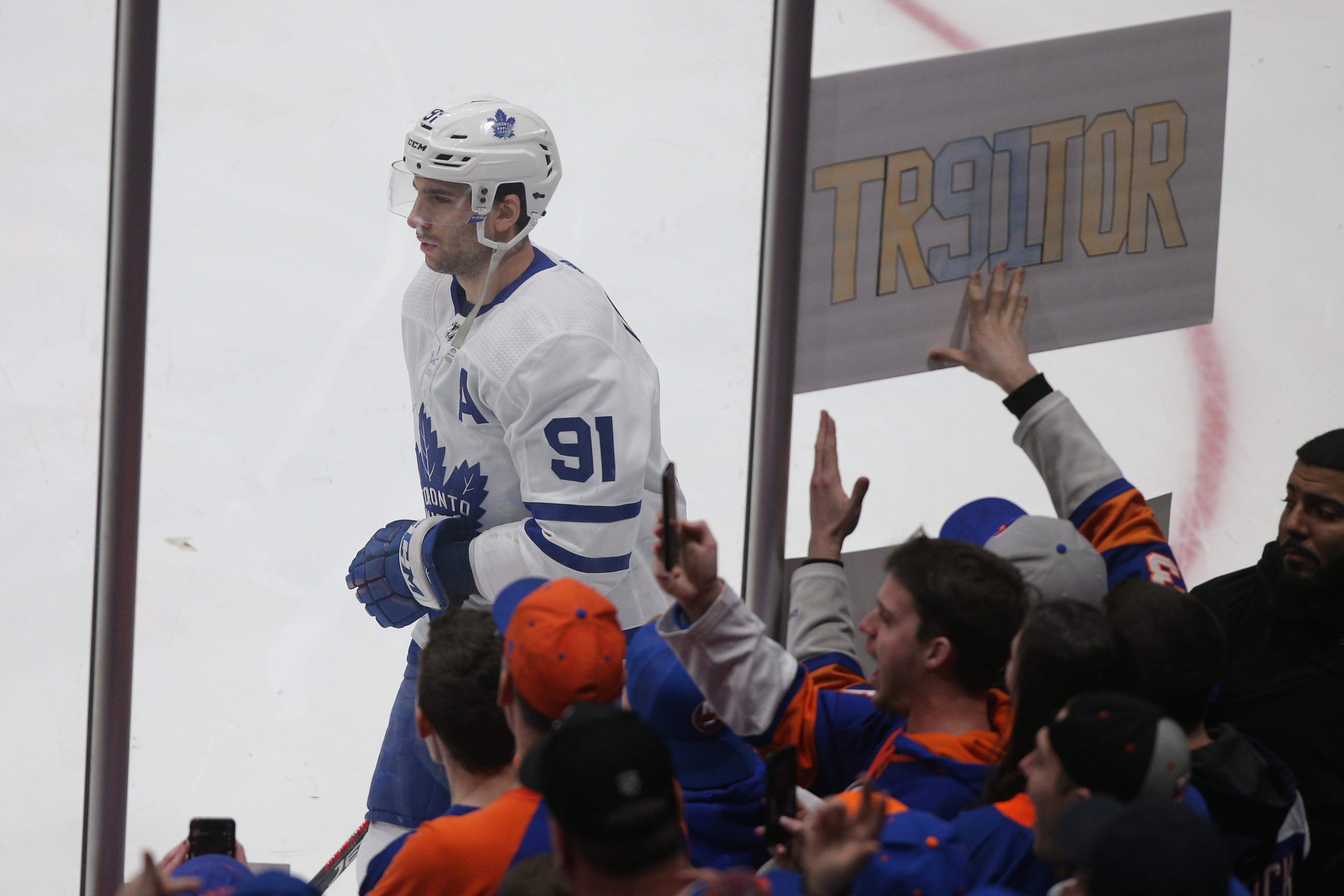 Feb 28, 2019; Brooklyn, NY, USA; Toronto Maple Leafs center John Tavares (91) skates past a sign held by a fan of the New York Islanders during warm ups before a game at the Nassau Veterans Memorial Coliseum. Mandatory Credit: Brad Penner-USA TODAY Sports