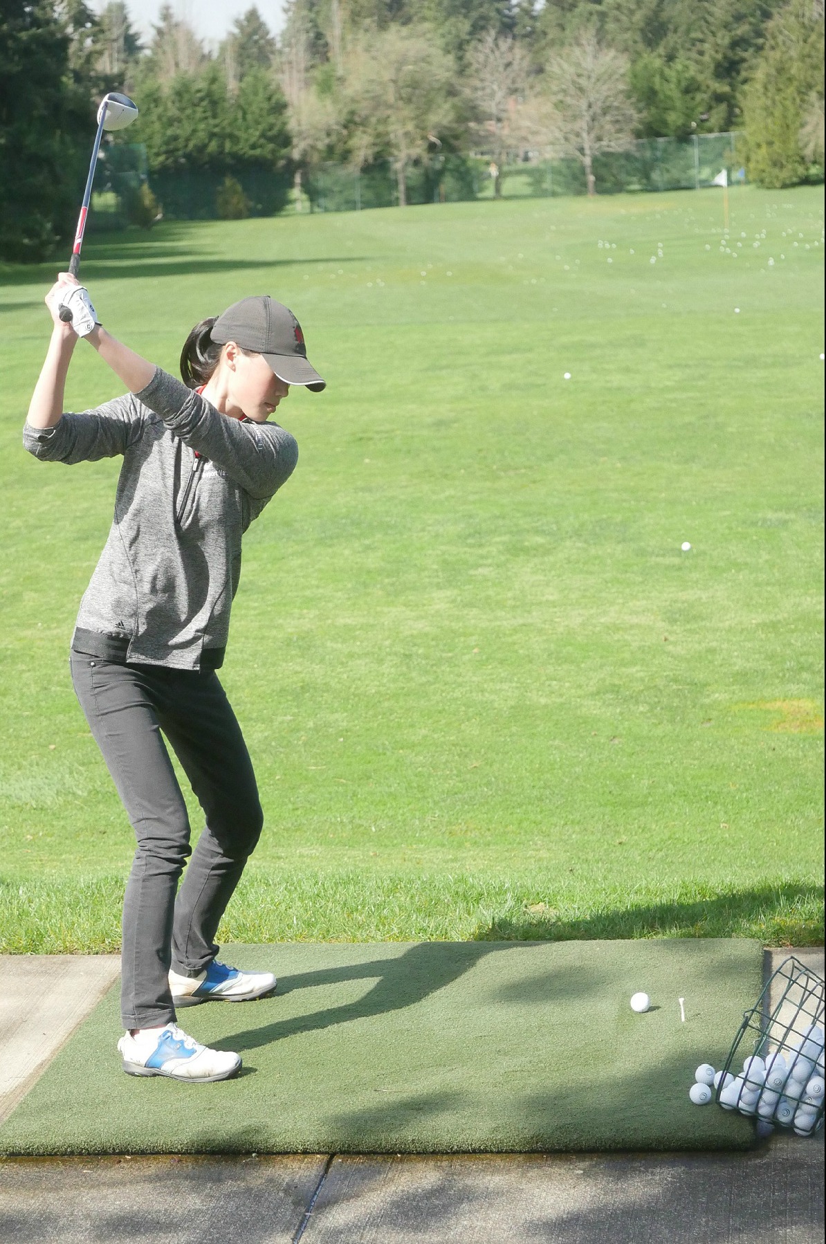 Marianne Li is no stranger to the driving range. She warms up at Overlake before a practice match against Bellevue.