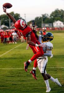 Manual's Jaelin Carter brings the ball down with one hand, against Central's Shawn Kel Knight, to score a touchdown. Aug. 21, 2015