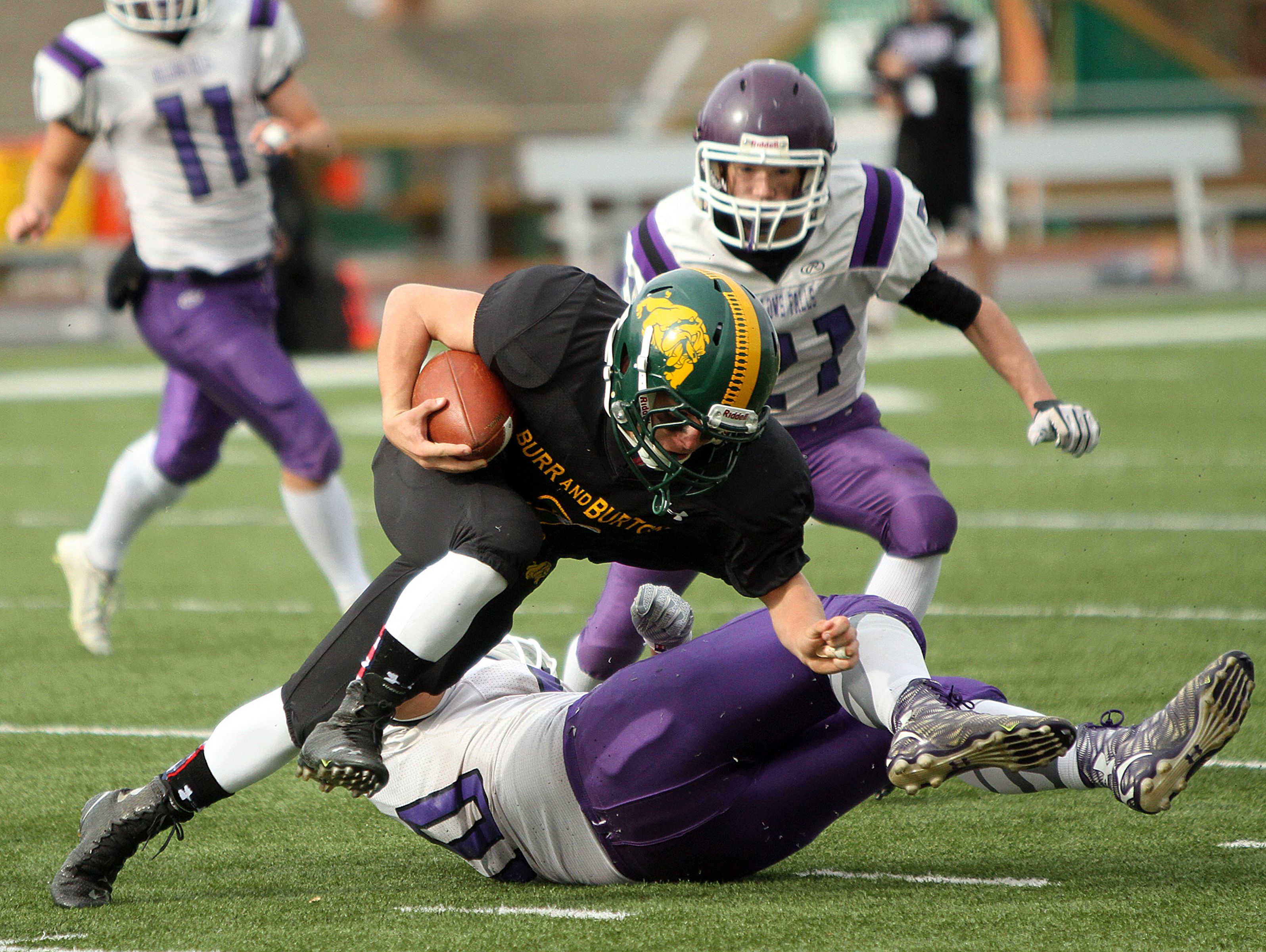 Burr and Burton's Ray Gormley is brought down by Bellows Falls' Jahyde Bullard in the second half of the Bulldogs 28-7 win over Bellows Falls in the Division II state high school football championship game on Saturday.