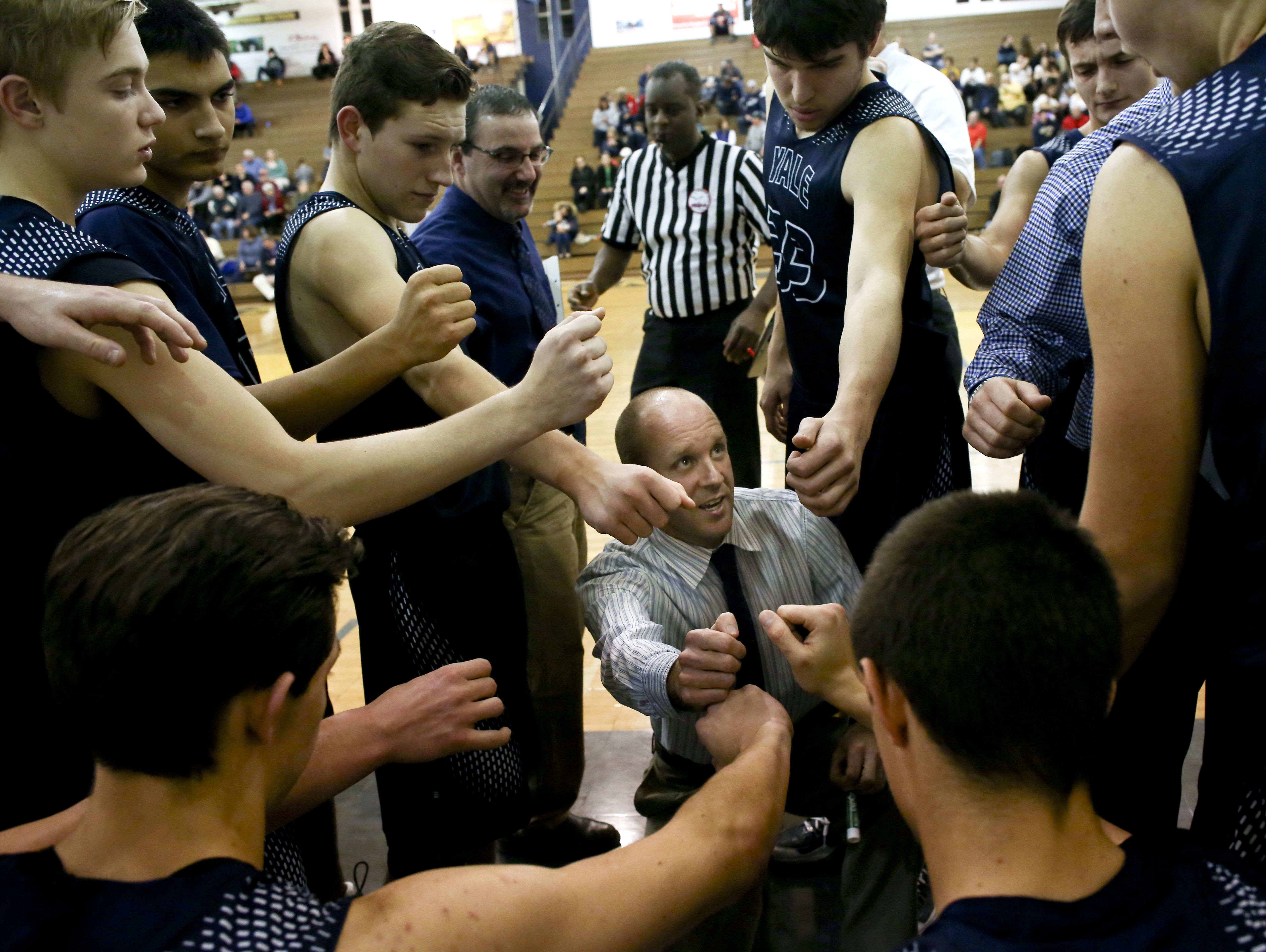 Yale players put their hands in a huddle with coach Garnett Kohler during a basketball game Tuesday, Jan. 5, 2016 at Port Huron Northern High School.
