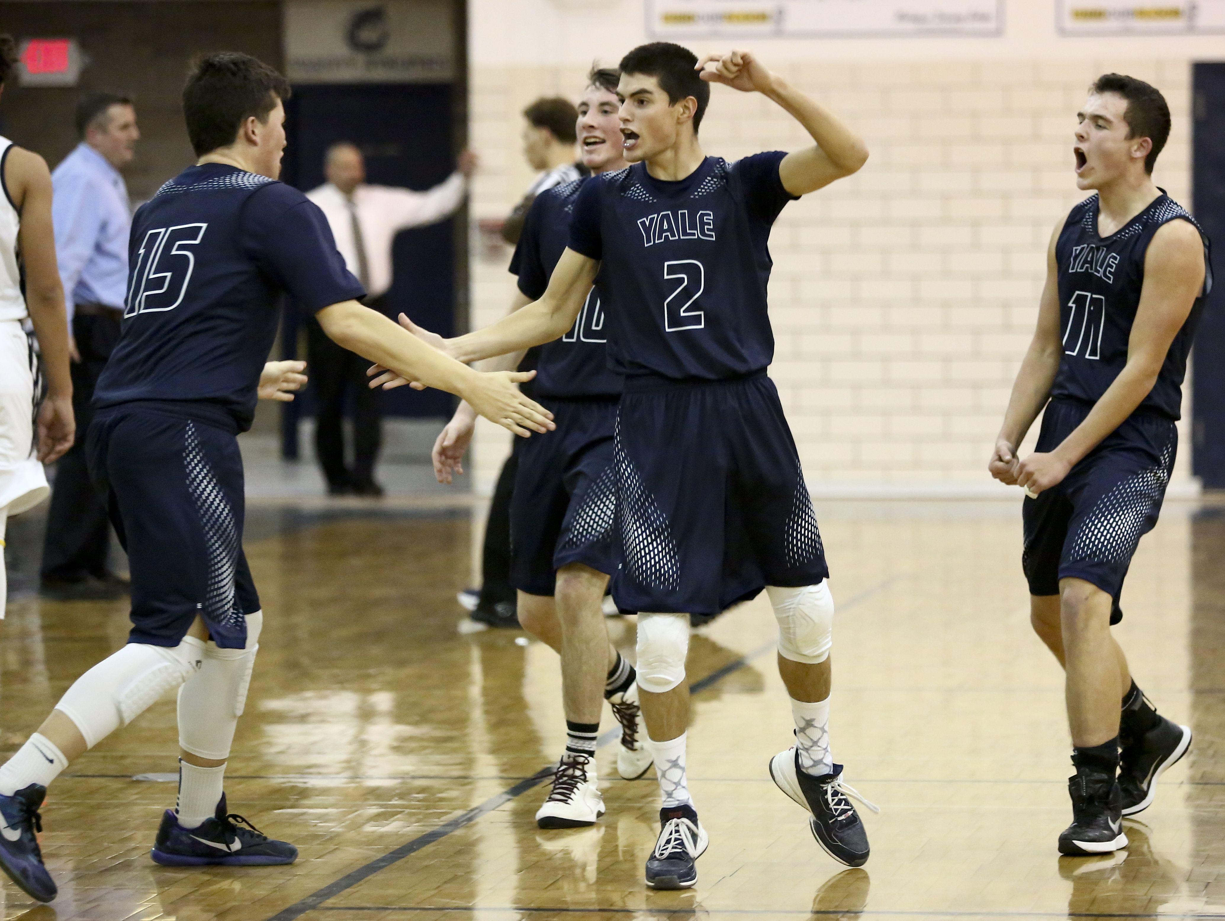 Yale junior Matthew Donnellon, left, sophomore Blake Pilgrim and sophomore Derik Porrett celebrate after scoring streak led to a Northern time out during a basketball game Tuesday, Jan. 5, 2016 at Port Huron Northern High School.