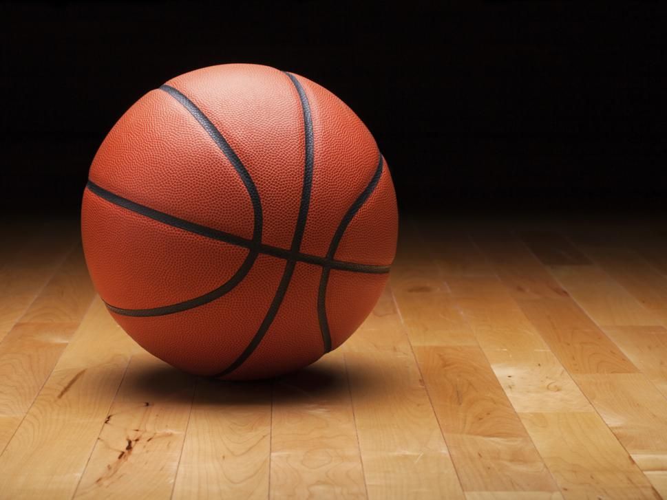 Basketball with dark background on a wood gym floor