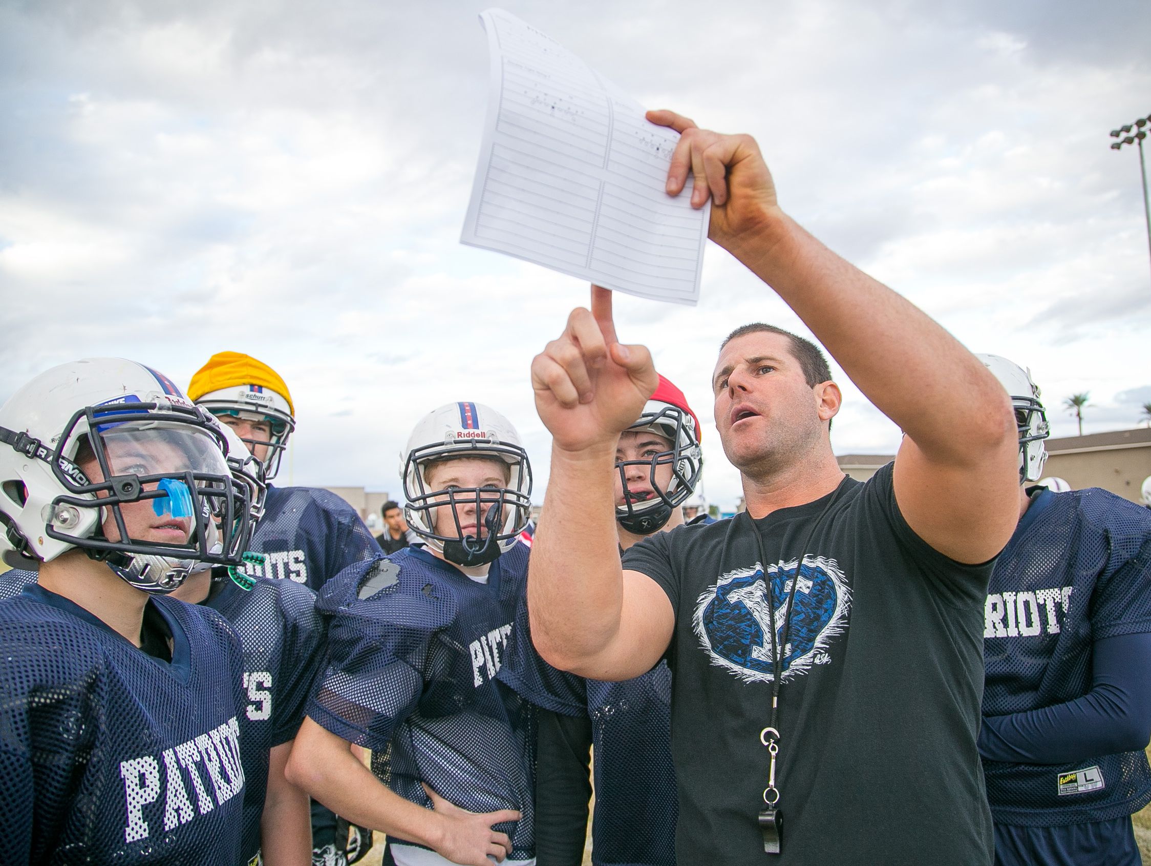 Offensive coordinator and former Arizona Cardinals quarterback Max Hall goes over plays at football practice at American Leadership Academy High in Queen Creek on Wednesday, November 4, 2015.