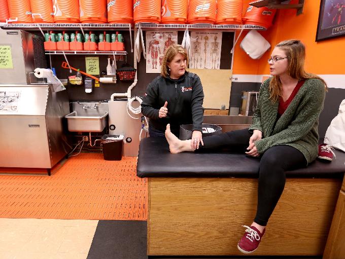 Athletic Trainer Amy West, left, helps junior Kaylyn Morgan with an ankle and foot injury from a car accident at Sprague High School in Salem on Tuesday, April 5, 2016.