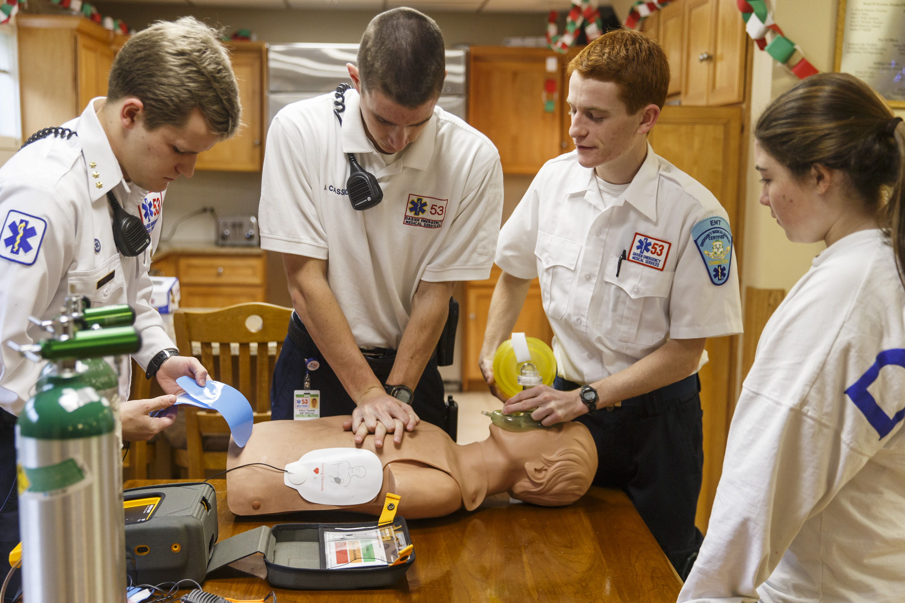Dec 20, 2014; Darien, CT, USA; EMS Post 53 vice pres of EMS Training and Darien High School swimmer Nicolai Ostberg (left), twin brother post 53 Cruise Officer & Darien High School cross country runner Alex Ostberg (2nd right), EMS student president & Darien High School track & field runner Arthur Cassidy (2nd left) and EMS Rider, high school student Emily Gianunzio (right) practice their CPR skills at Post 53 in Darien, CT Saturday morning during their on-call shift. Mandatory Credit: David Butler II-USA TODAY Sports ORG XMIT: US 132289 Alex Ostberg 12/20/2014 [Via MerlinFTP Drop]
