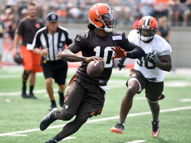 Cleveland Browns quarterback Robert Griffin III escapes from defensive back Derrick Kindred and passes down field during the Orange and Brown Scrimmage on Saturday at Ohio Stadium in Columbus.