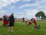 Head coach Ryan Mullins looks on as a pair of Big Reds go through a tackling drill Friday, Aug 12, during practice at Port Huron High School.