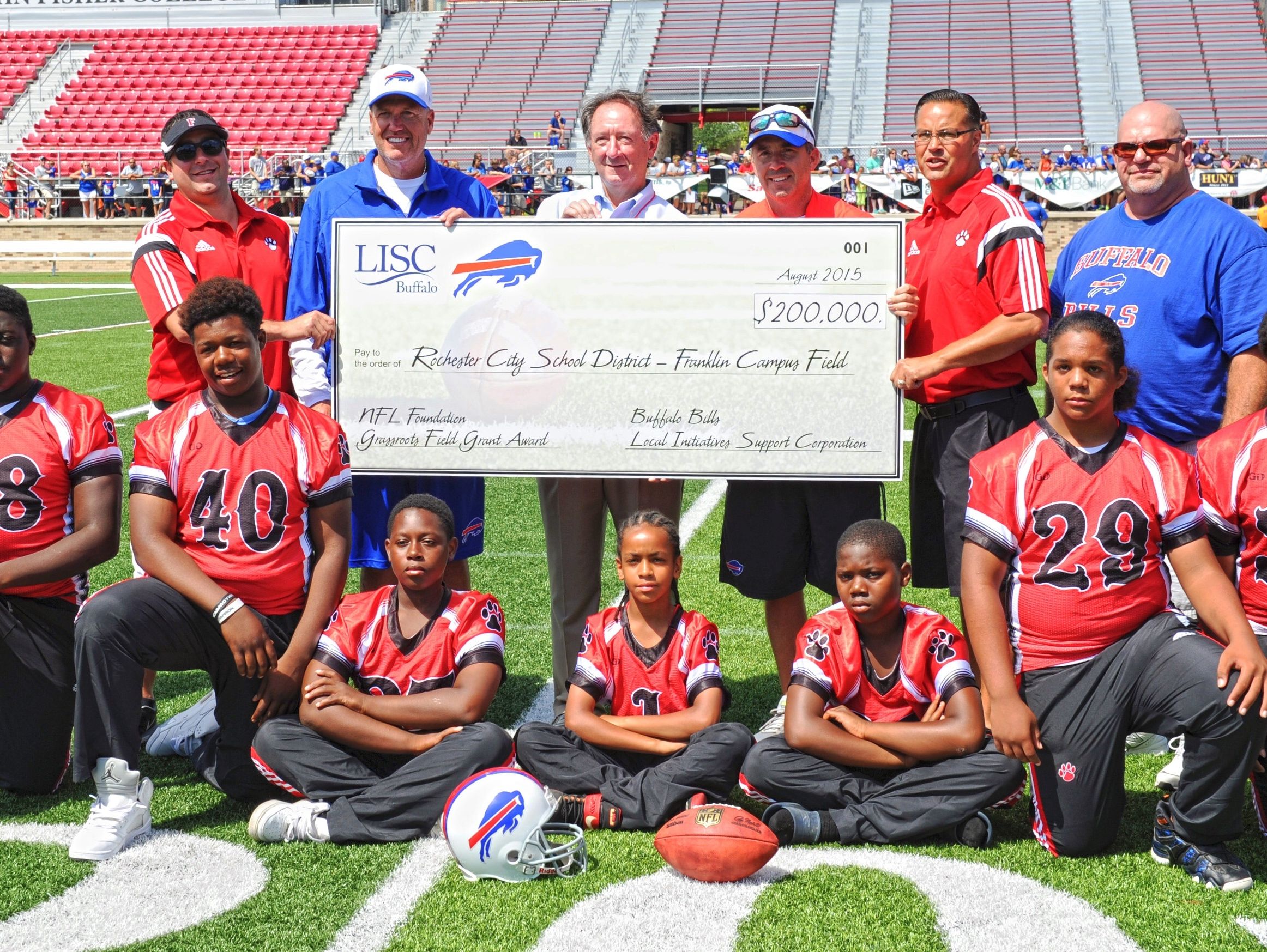 Franklin modified football team members with (back row, from left) Jason George, Franklin coach; Rex Ryan, Bills coach; Michael Clarke, executive director of Local Initiatives Support Corporation-Buffalo; Russ Brandon, Bills president; David Boundy, Franklin Campus athletic director; and Kevin Klein, Integrated Arts and Technology High School principal. A check for $200,000 was presented last year to help construct a new synthetic turf field.
