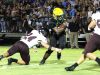 Catholic's Abram Smiley breaks a tackle attempt by Navarre's Reese Parker (24).