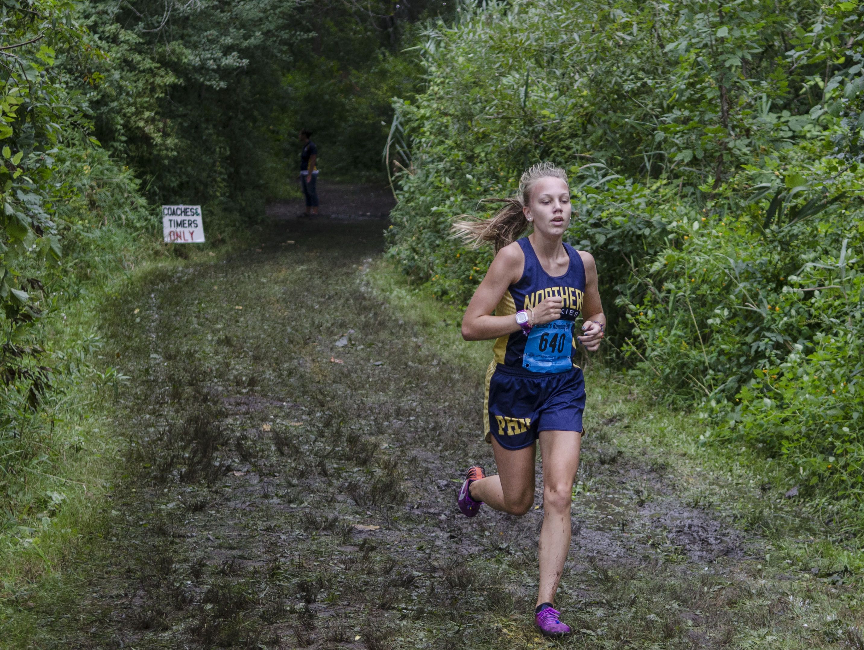 Port Huron Northern's Ashley Defrain runs out of the wood loop in front of the pack in the Division I race Saturday, Sept. 10 at the Algonac Muskrat Cross Country Classic at Algonac High School. Defrain finished in first place with a time of 19:46.