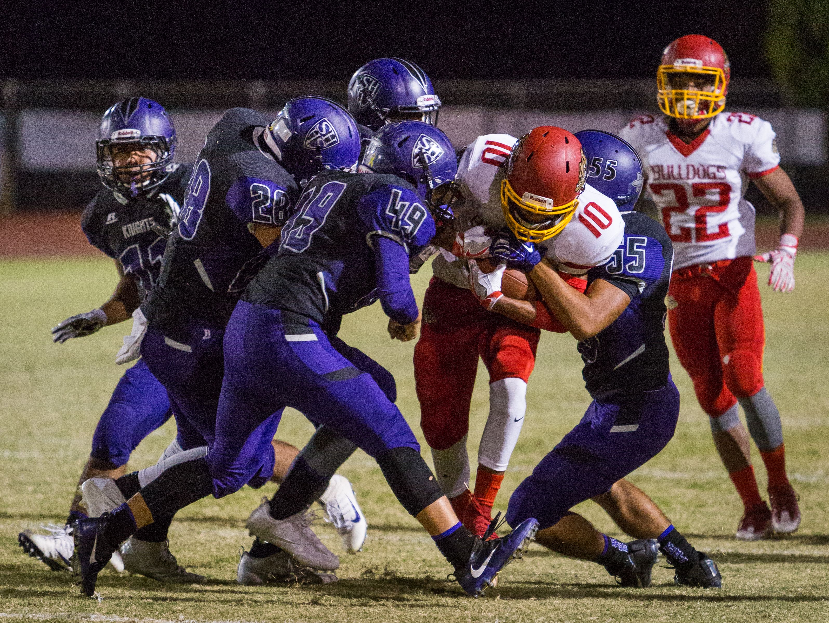 Kyle Serna (#10) was met by four Shadow Hills defenders but managed to get the Bulldogs a first down.