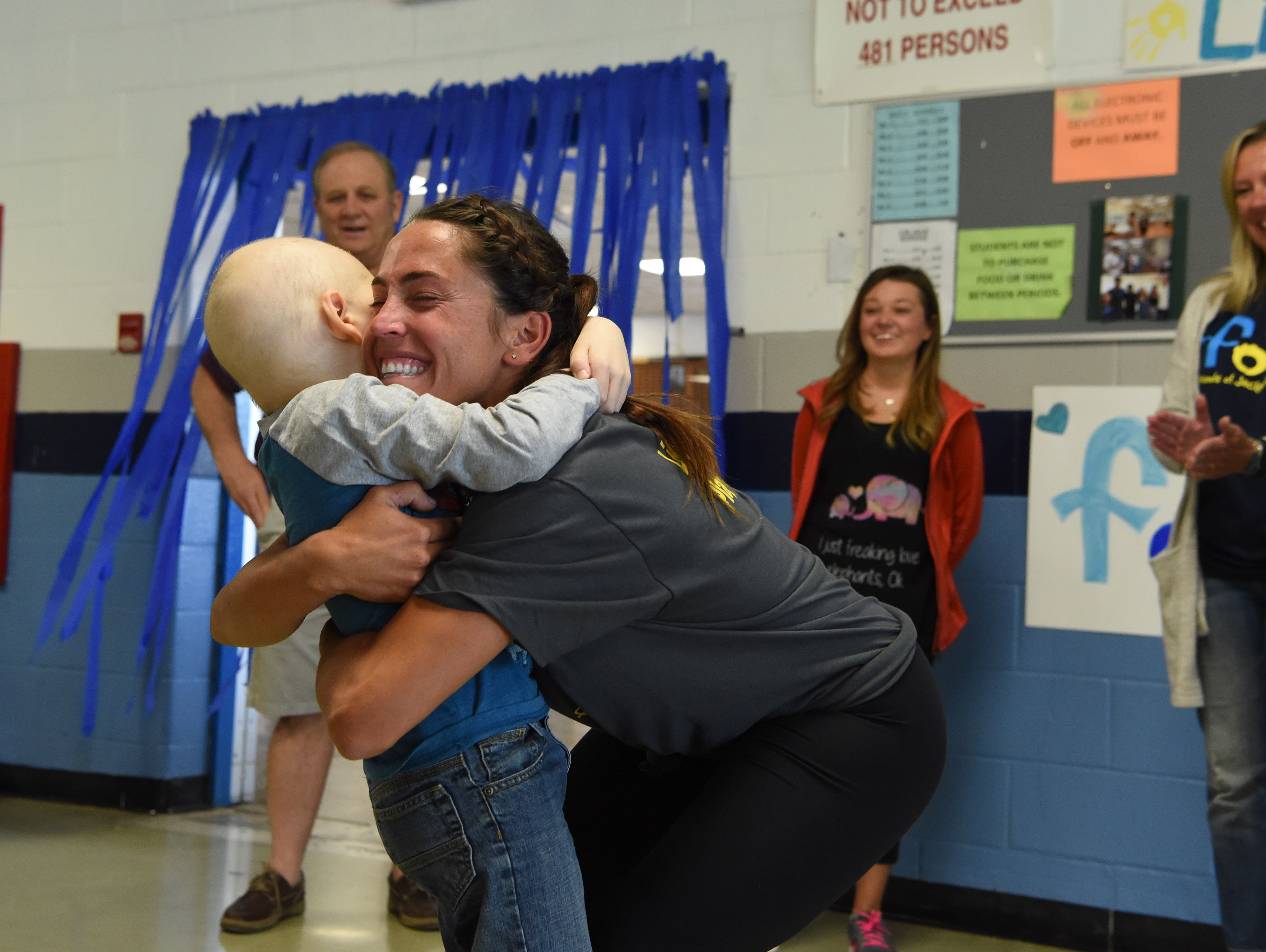 Kristen Perry, right, a physical education teacher and the field hockey coach at John Jay High School, gives a hug to Liam Craane, 5, who is battling pediatric cancer. The school's field hockey team "adopted" Liam through the Friends of Jaclyn Foundation.