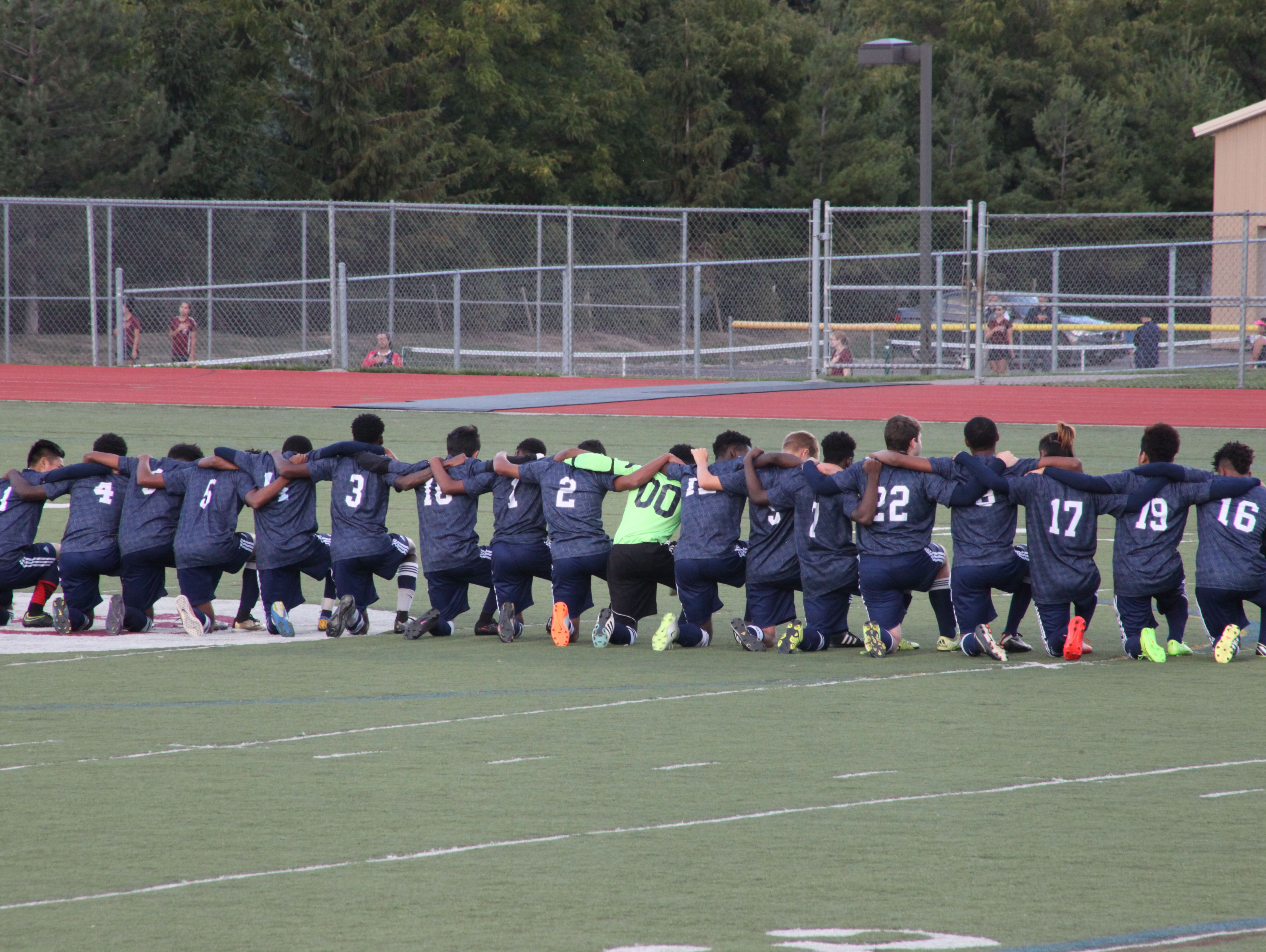 The entire World of Inquiry/School 58 boys soccer team knelt during the national anthem before Tuesday's 1-0 win at Aquinas Institute.